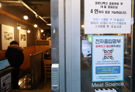 14일 오후 서울 종로구의 한 식당 입구에 방역패스(백신접종증명·음성확인제) 관련 안내문이 부착돼 있다. <연합뉴스>